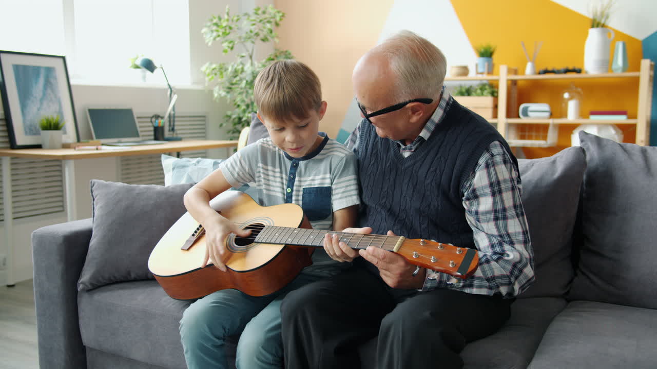 Nonno che insegna al nipote a suonare la chitarra