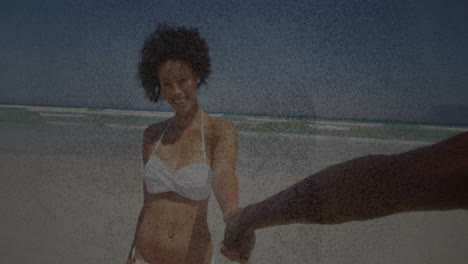 holding hand on sandy beach, woman smiling in white bikini with animation