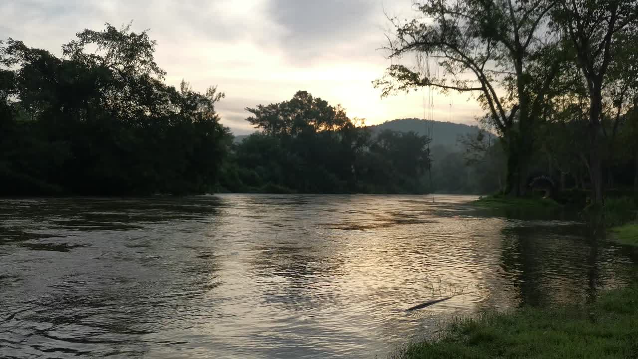 Alba mattutina, fiume in piena con sfondo panoramico, Thailandia