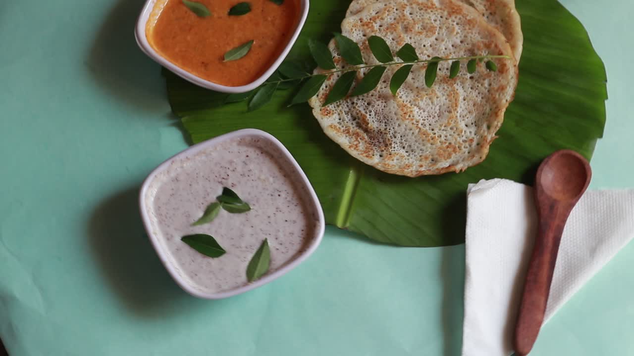 set dosa es un 'conjunto' de 2 dosas cubiertas con mantequilla o ghee y chutney sobre fondo verde