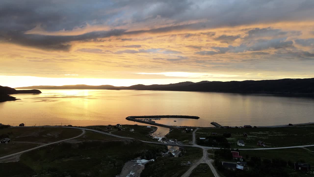 노르웨이 해변 마을 근처 잔잔한 바다 위에 황금빛 일몰