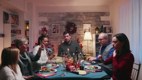 diferentes generaciones alrededor de la mesa celebrando la navidad