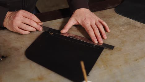 leather craftsman measuring leather