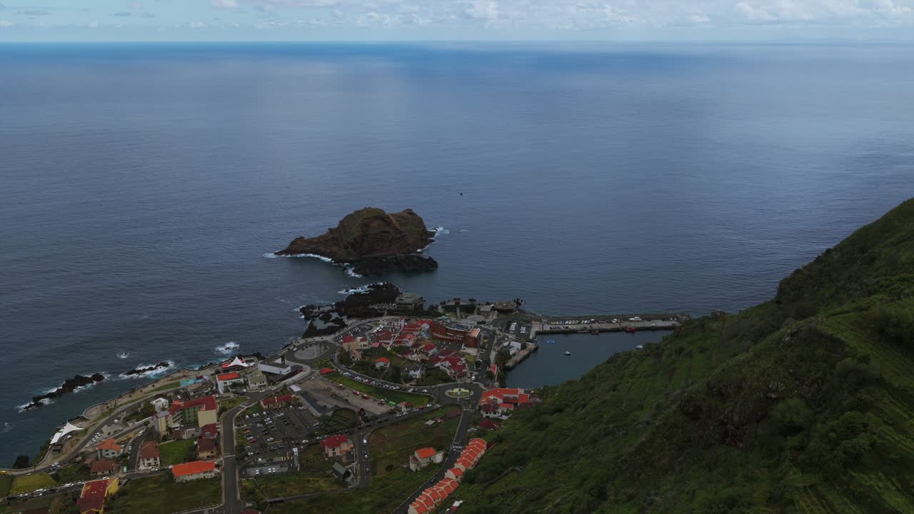 Ripresa aerea con drone della città costiera di Porto Moniz, delle famose piscine naturali di lava vulcanica e dell'isolotto Ilhéu Mole, Madeira, Portogallo. Inclinazione aerea verso il basso