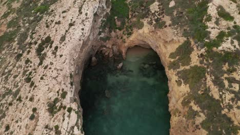 Drone-descends,-unveiling-stunning-rugged-rock-formations-on-Gozo's-coast