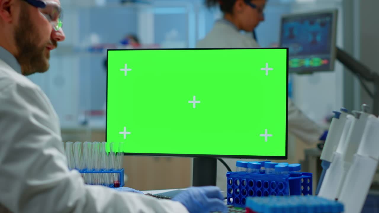 hombre trabajando en una pc con pantalla verde en un laboratorio modernamente equipado