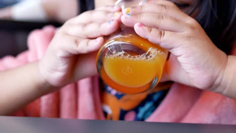 child drinking orange juice closeup,