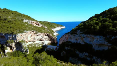 Hermoso-Paisaje-Escénico-De-Una-Isla-Tropical-Con-Un-Mar-Que-Fluye-A-Través-De-Los-Acantilados-Y-Picos-Con-Un-Exuberante-Follaje-Que-Lo-Rodea-A-Ambos-Lados