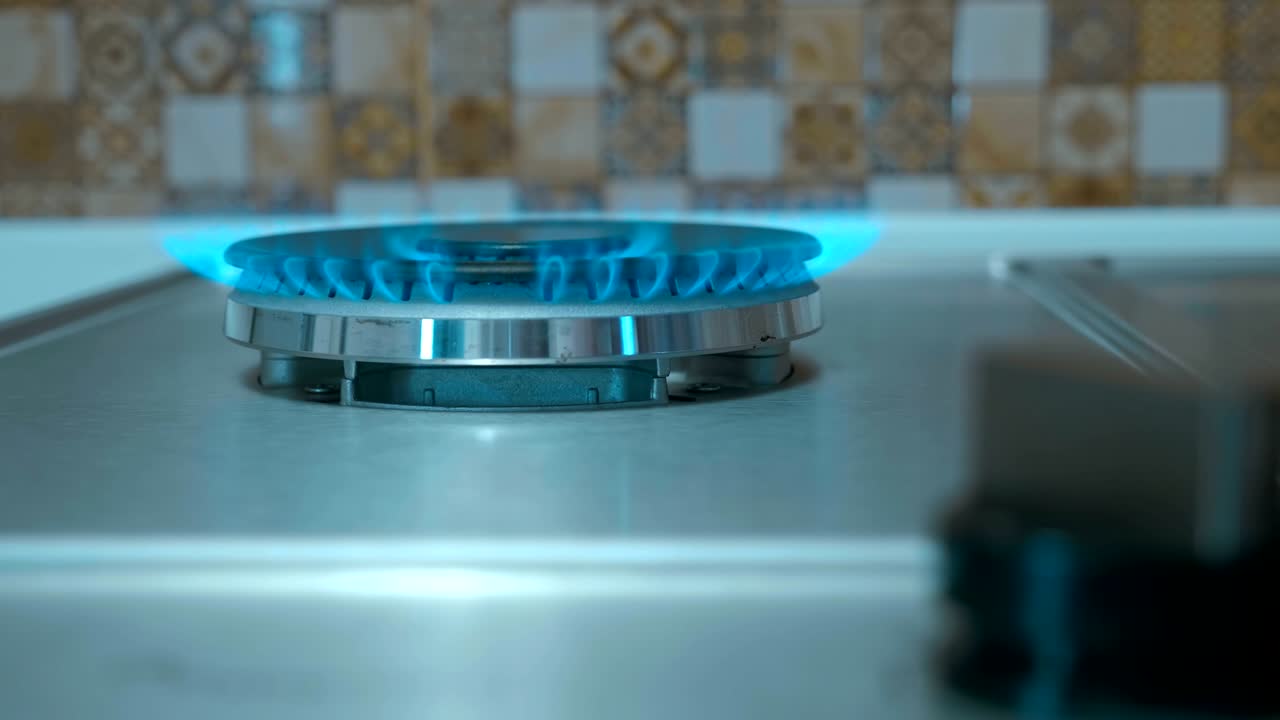 부에 있는 스토브에 가스가 불타고 있다. 손가락으로 가스 브를 돌려라.