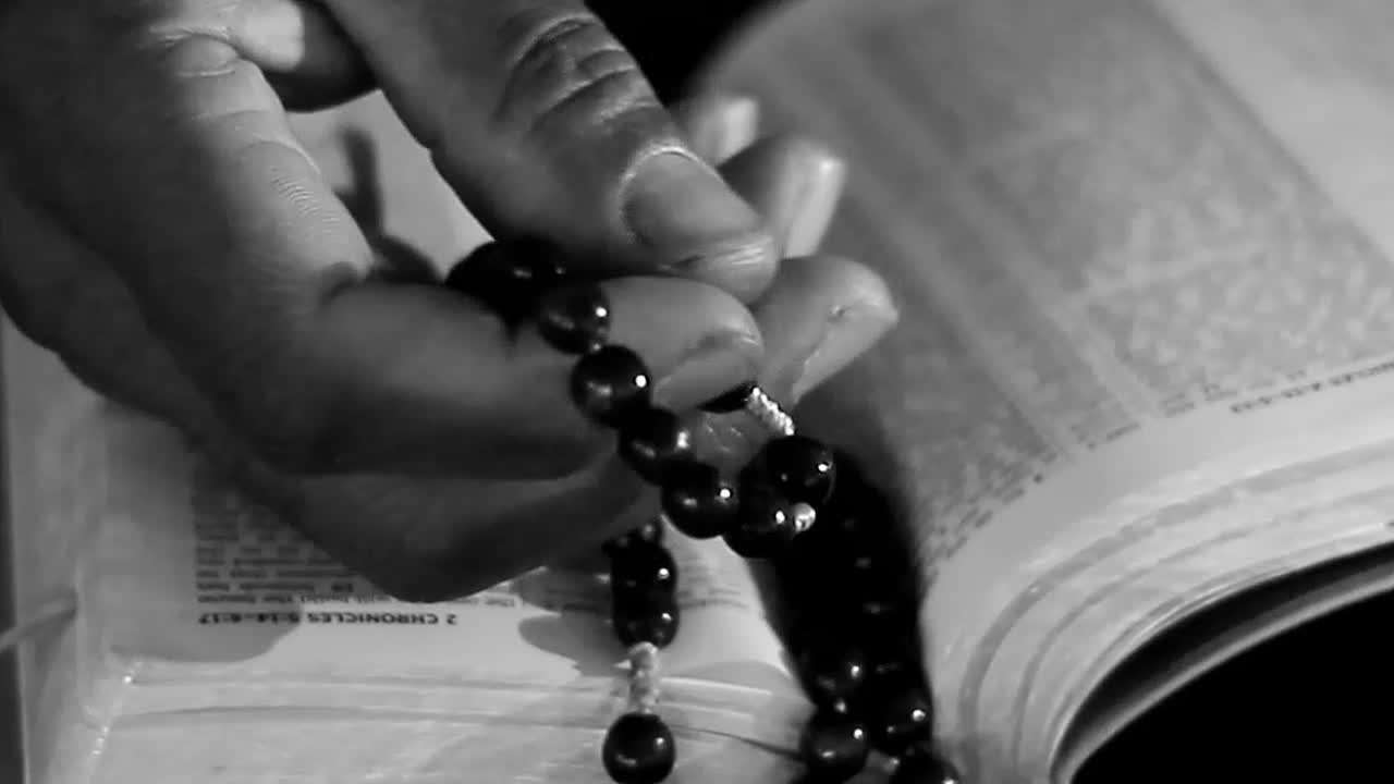 Pessoas orando com a bíblia sagrada e cruz sobre a mesa - vídeo de arquivo.