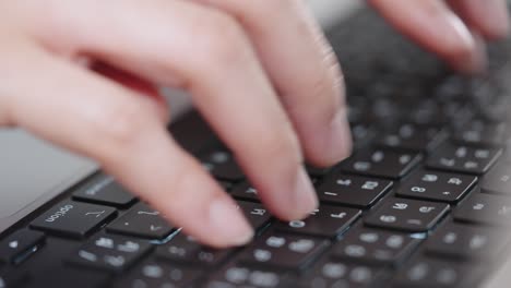 fotografía de cerca de las manos de una mujer de negocios escribiendo en el teclado de una computadora portátil para buscar información, soporte de comunicación en línea, investigación de mercadotecnia, informe de negocios en el escritorio de la oficina por la noche.