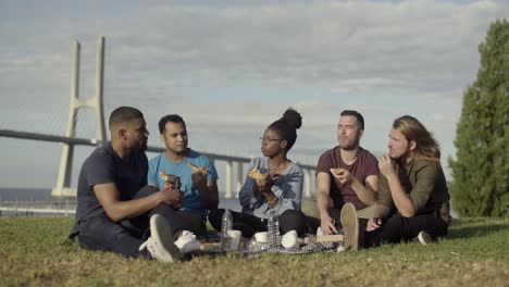 relaxed friends having picnic in park