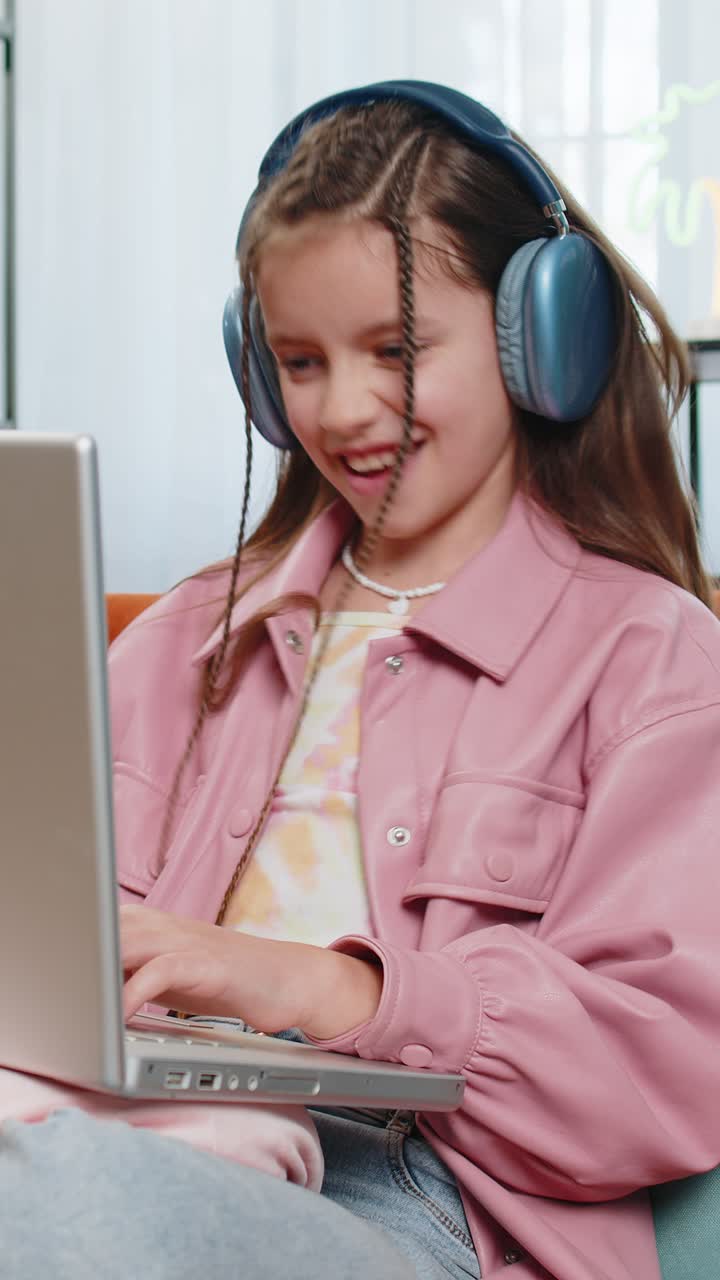 niña con auriculares usando portátil escucha música o lección educación a distancia en casa