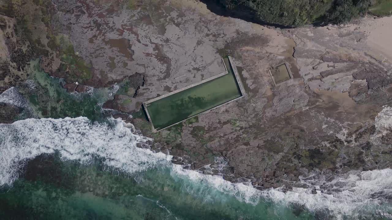 오스트레일리아 콜데일 (coledale) 의 바위가 있는 해안선의 위상과 바위가 바가에 부히는 파도와 바위 위에 새겨진 야외 수영장