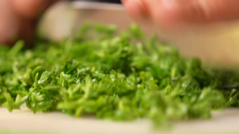 Chopping-parsley-with-a-knife-on-a-cutting-board---macro-isolated