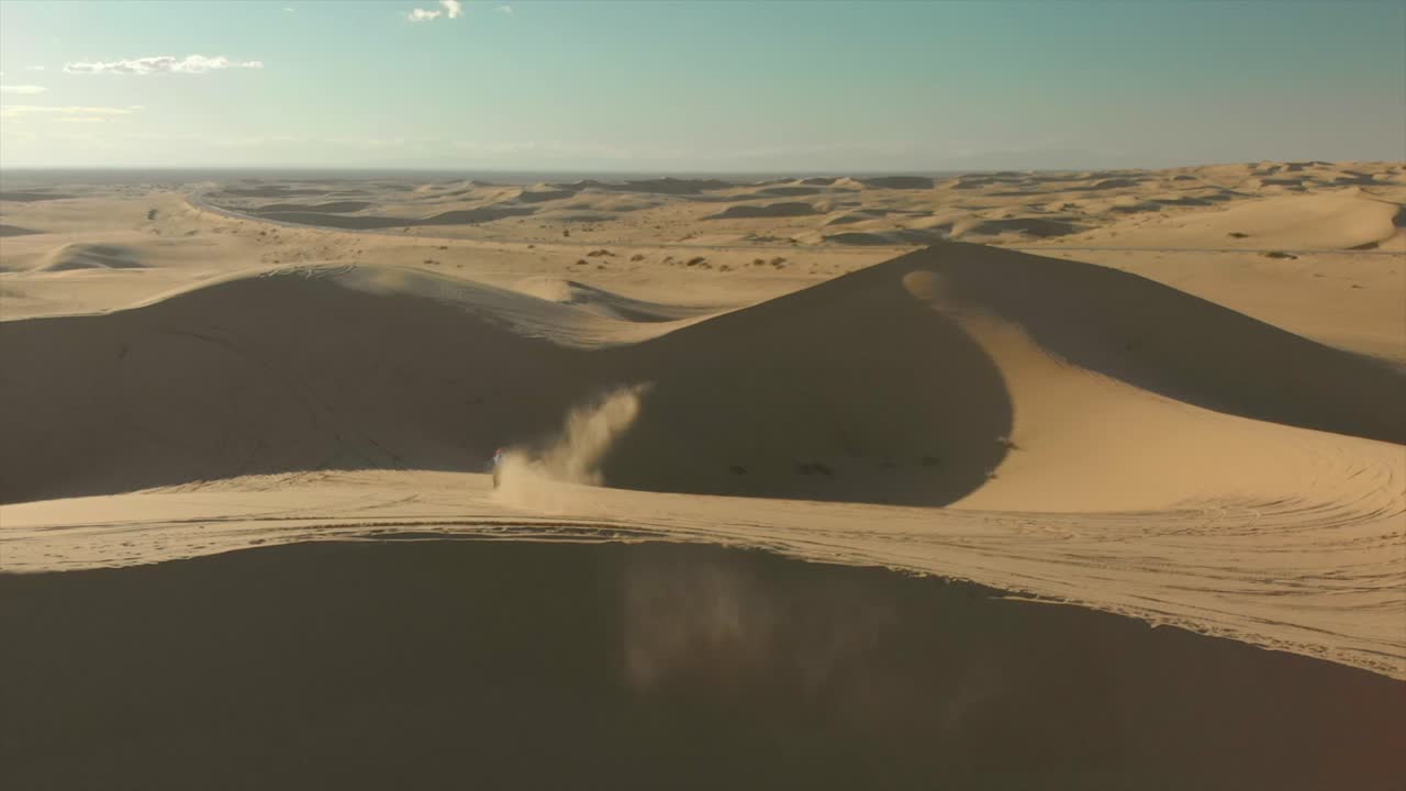 antena de dunas de arena del desierto con motocross y un hombre corriendo