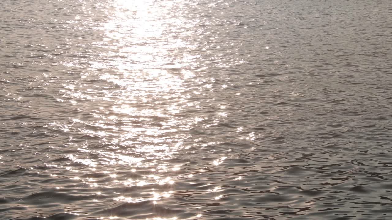 일몰 시간에 물 표면에 빛 반사