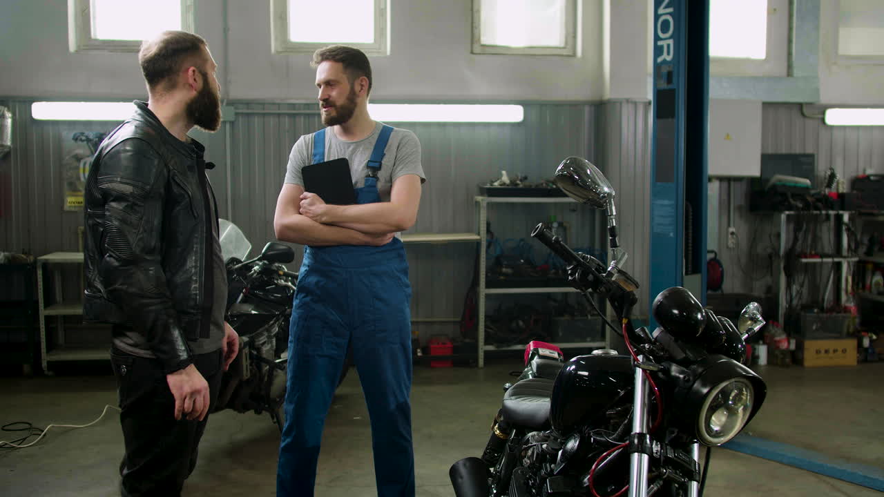 기계공과 라이더가 차고에서 대화하고 있습니다.