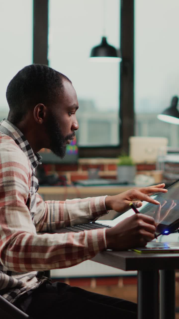 Vertical video: Male graphic designer editing pictures on retouching software