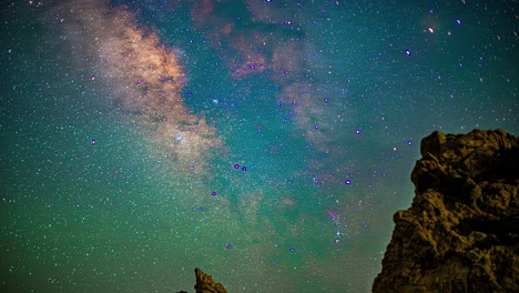 Lapso-De-Tiempo-De-La-Vía-Láctea,-Estrellas-En-El-Cielo-Nocturno-Moviéndose-Sobre-El-Pico-De-La-Montaña-Rocosa