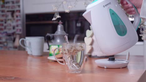 peaceful kitchen scene, water poured into teacup from electric kettle