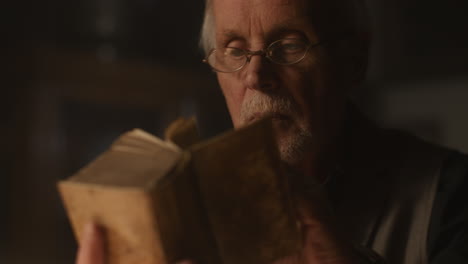 old passionate man read a book in his office at night