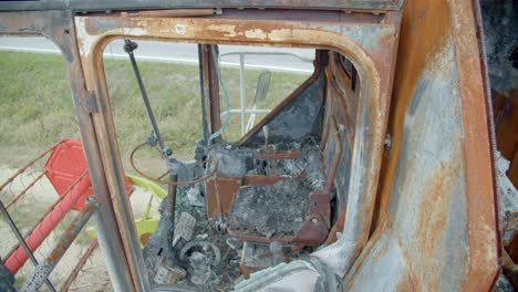 close up of a broken and burnt out combine harvester in countryside field