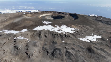 tomada de avión no tripulado del pico uhuru en el monte kilimanjaro volando hacia el cráter volcánico. tomada aérea de ángulo descendente