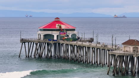 an aerial 4k video shows a pier stretching out into the ocean