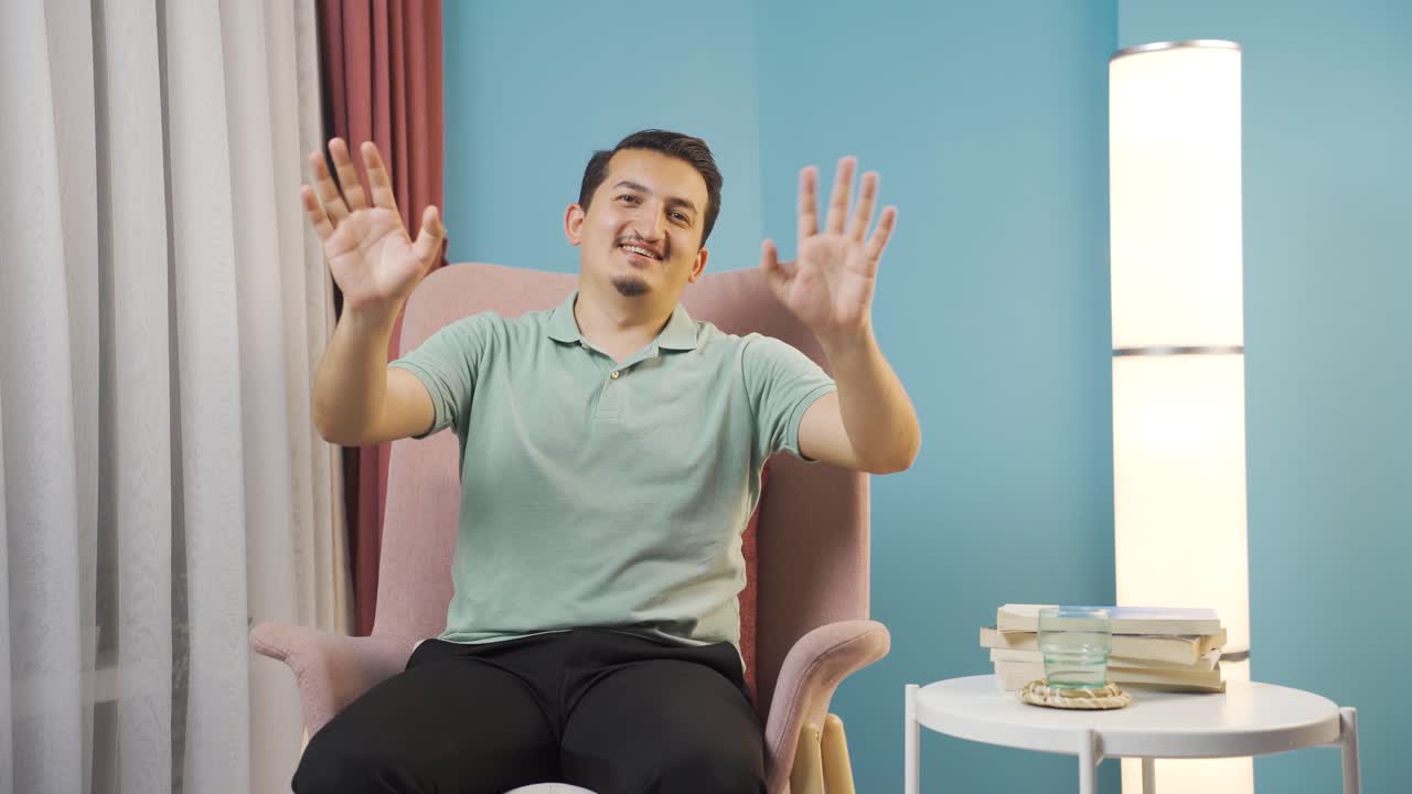 카메라를 향해 손을 흔들고 있는 남자