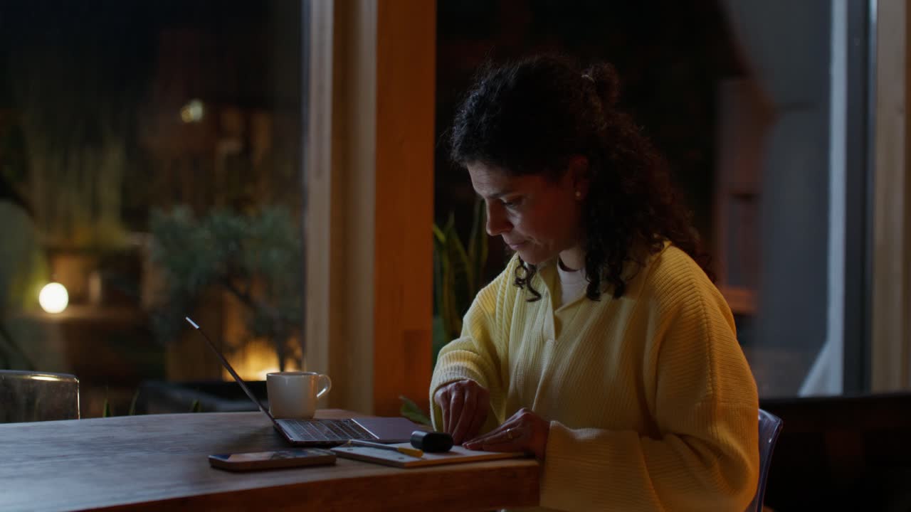 Woman working on laptop at night