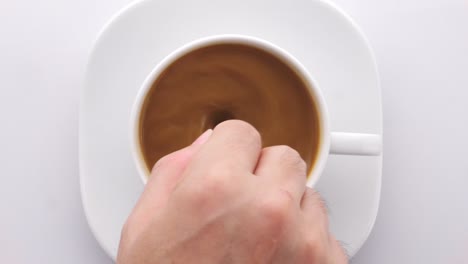 top view person hand stirring coffee with spoon
