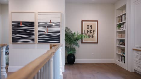 Hallway-with-plant,-bookshelf,-and-'On-Lake-Time'-picture