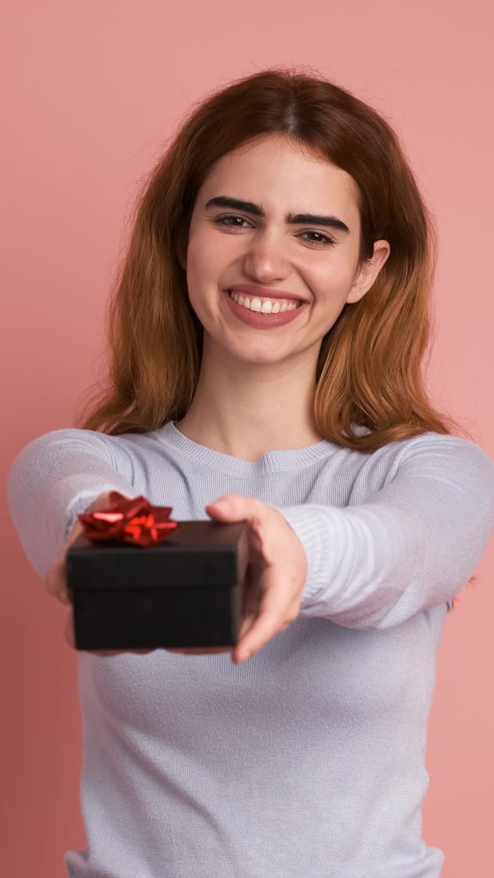 Happy woman giving a present and smiling. Vertical Footage