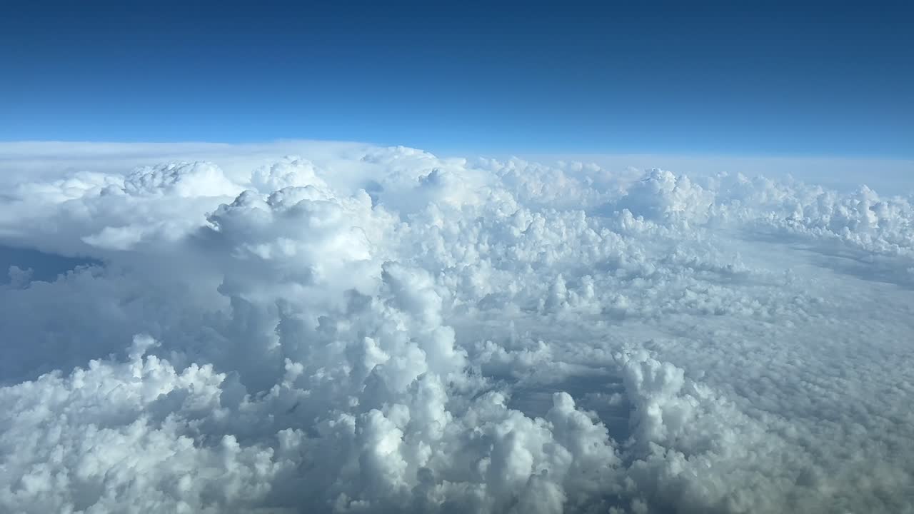 크루즈 수준에서 날아다니는 비행기 조종실에서 위에서 볼 수 있는 폭풍우 구름으로 가득 찬 파란 하늘