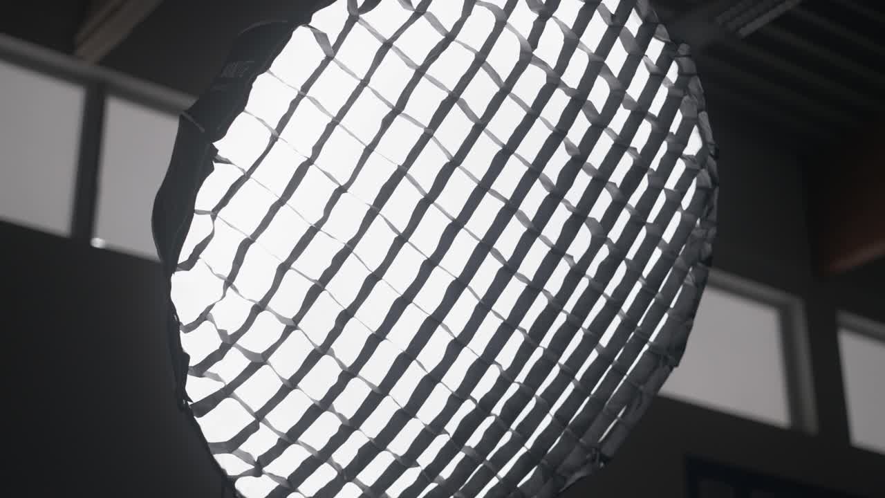 Orbit medium shot of parabolic softbox strobe light in studio