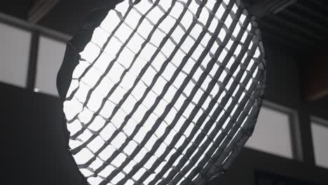 orbit medium shot of parabolic softbox strobe light in studio