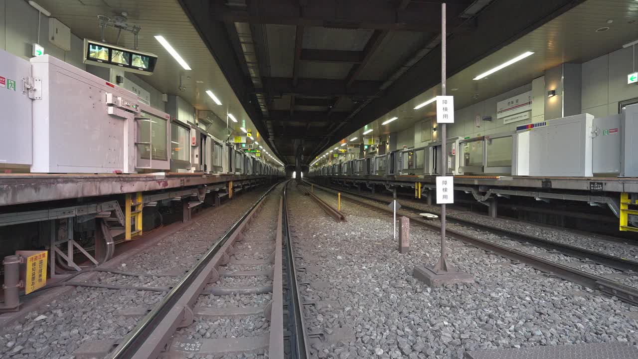 A long exposure view of the underground platform and tracks at Shinsen Station in Tokyo, Japan, emphasizing urban transportation infrastructure.