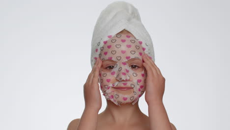 child girl applying cosmetic moisturizing face mask, teenager facial skin care, natural cosmetics