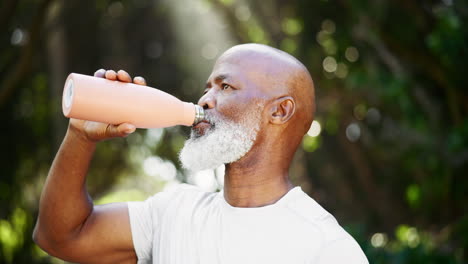 man drinking water outdoors