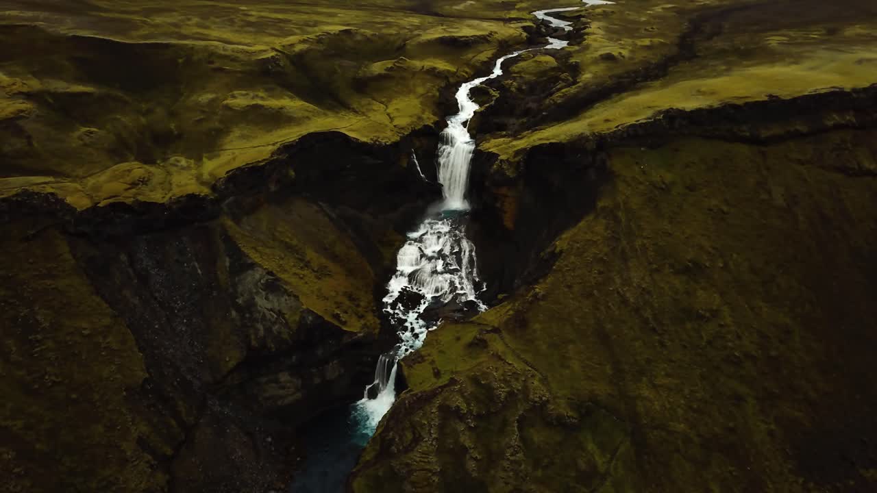 vista panorámica aérea sobre el agua que fluye por la cascada ófærufoss, en las tierras altas de islandia