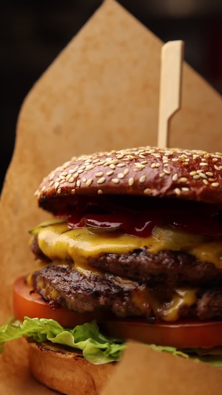 Nærbillede af en lækker dobbelt cheeseburger indpakket i papir