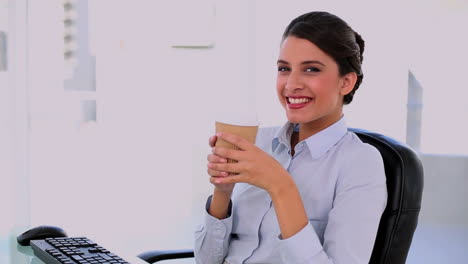 una mujer de negocios hermosa y pacífica disfrutando del café.