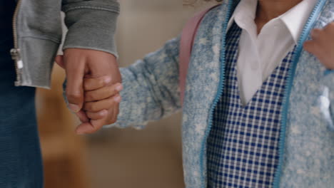 padre sosteniendo a las hijas de la mano llevando a la niña a la escuela