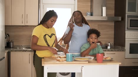family preparing and enjoying breakfast together in the kitchen