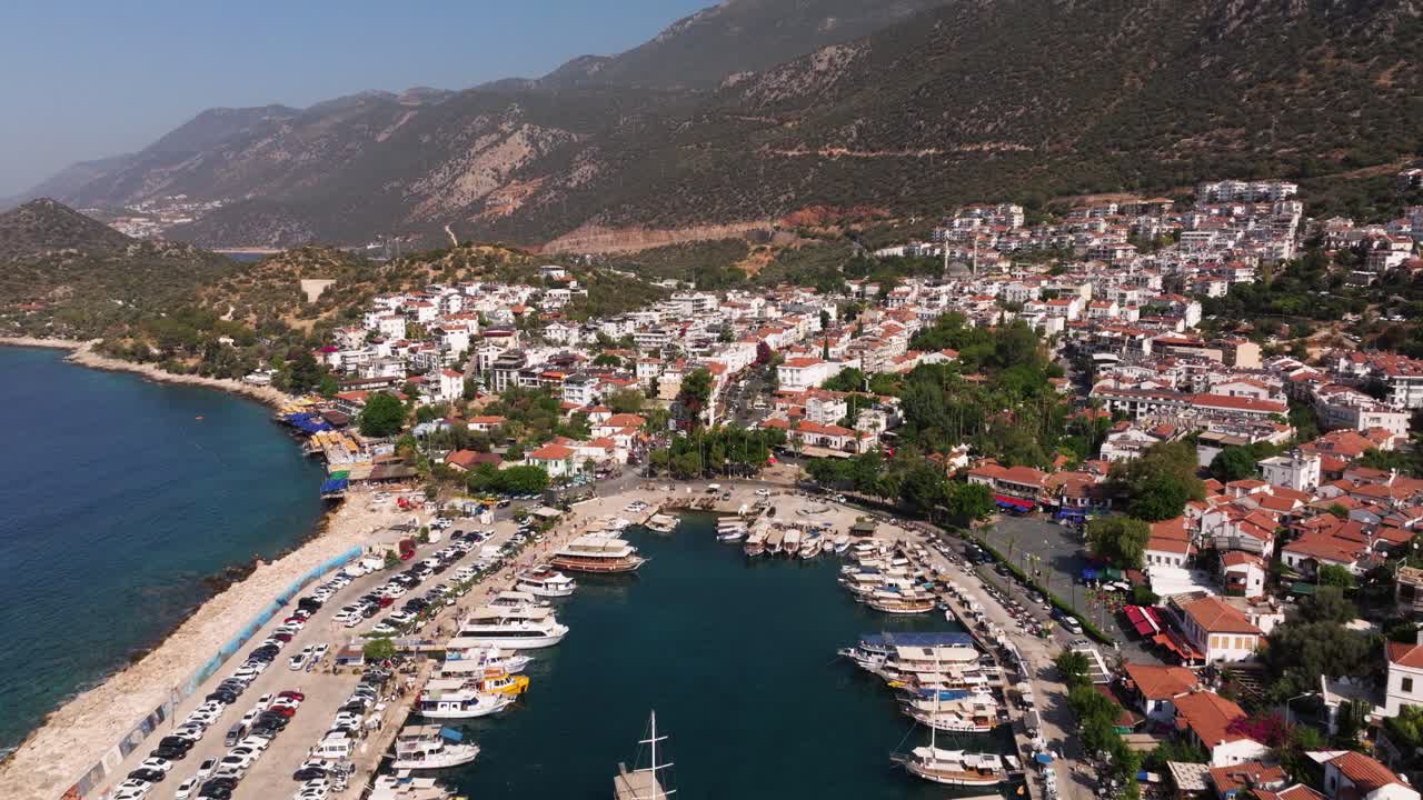 Long drone dolly above Kas, Antalya, Turkey, showing the town’s rooftops, marina, and coastal scenery with blue Mediterranean waters