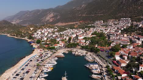 long drone dolly above kas, antalya, turkey, showing the town’s rooftops, marina, and coastal scenery with blue mediterranean waters