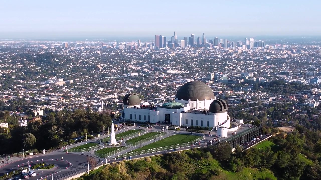 Osservatorio Griffith con vista sul centro di Los Angeles, California. Orizzonte della città in una giornata limpida e soleggiata. Prato recintato senza persone su erba perfetta. Ingrandito per un effetto maggiore in 4k.