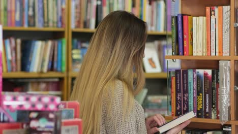 girl chooses a book in a bookstore