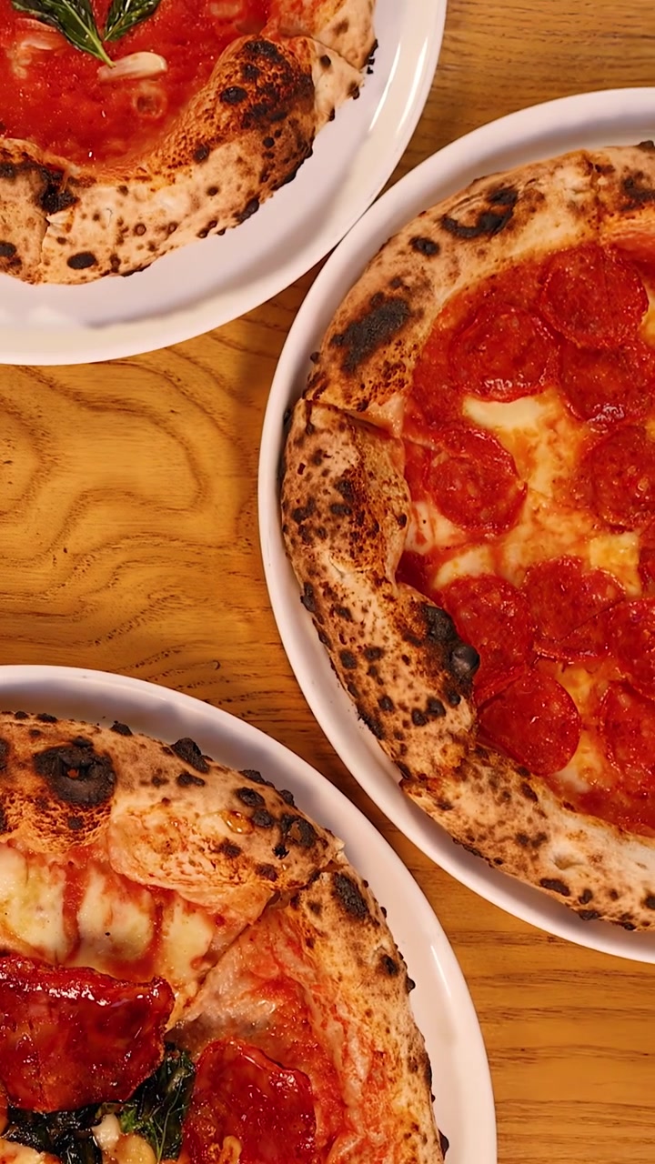 Topbillede af friskbagte napolitanske pizzaer på træbord